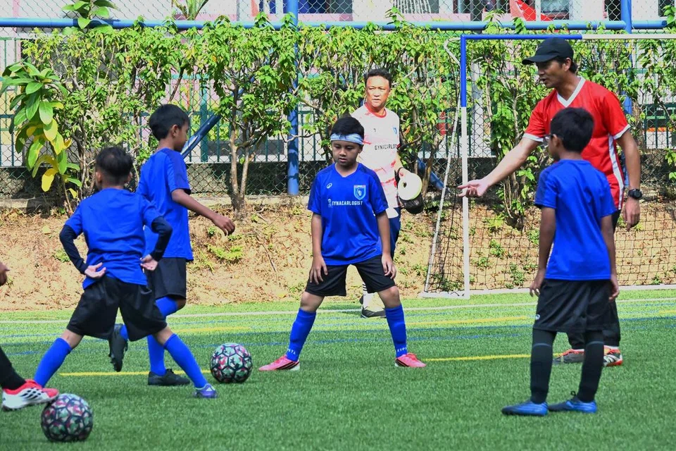 Bekas penyerang kebangsaan, Indra Sahdan (kanan), berkongsi kemahiran serta pengalaman di padang bagi memastikan anak muda seronok menikmati permainan bola sepak.