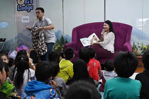 ACARA CUTI KELUARGA: Encik Herman Rothman dan Cik Nursha Ismail mewakili NLB kendali sesi bercerita bersama kanak-kanak keluarga penerima Fitrah di Snow City Singapura anjuran Fitrah semalam. - Foto BM oleh KHALID BABA