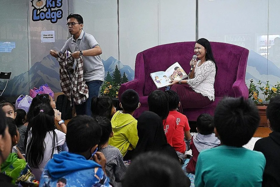 ACARA CUTI KELUARGA: Encik Herman Rothman dan Cik Nursha Ismail mewakili NLB kendali sesi bercerita bersama kanak-kanak keluarga penerima Fitrah di Snow City Singapura anjuran Fitrah semalam. - Foto BM oleh KHALID BABA