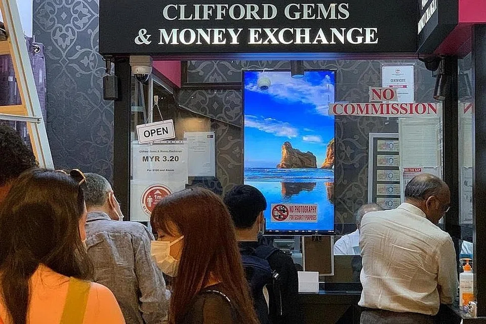 BERATUR PANJANG: Beberapa pelanggan kelihatan beratur panjang di Clifford Gems & Money Exchange di Raffles City bagi menukar mata wang asing Khamis lalu. - Foto CLIFFORD GEMS AND MONEY EXCHANGE