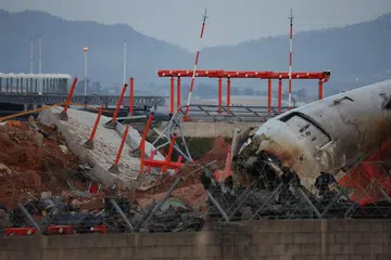 FOTO FAIL: Serpihan pesawat Jeju Air yang tergelincir dari landasan dan terhempas di Lapangan Terbang Antarabangsa Muan kelihatan berhampiran struktur konkrit yang dirempuhnya, di Muan, Korea Selatan, 30 Disember 2024.