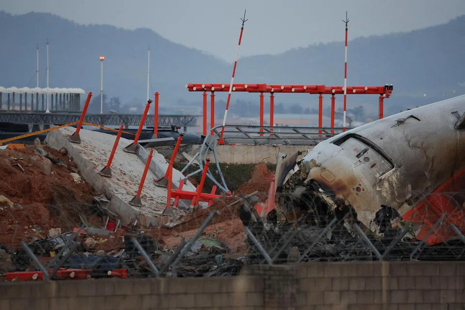 FOTO FAIL: Serpihan pesawat Jeju Air yang tergelincir dari landasan dan terhempas di Lapangan Terbang Antarabangsa Muan kelihatan berhampiran struktur konkrit yang dirempuhnya, di Muan, Korea Selatan, 30 Disember 2024.