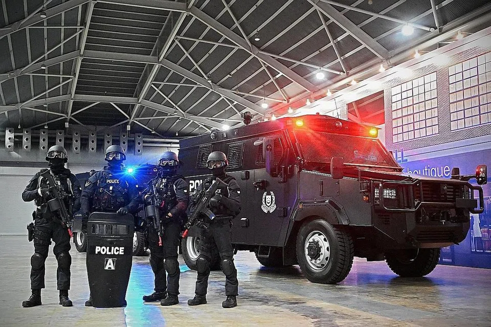 KENDERAAN BERPERISAI: Pegawai Komand Operasi Khas bergambar bersama kenderaan taktikal baru di pameran dan seminar pelan kerja polis pada Jumaat. - Foto ST