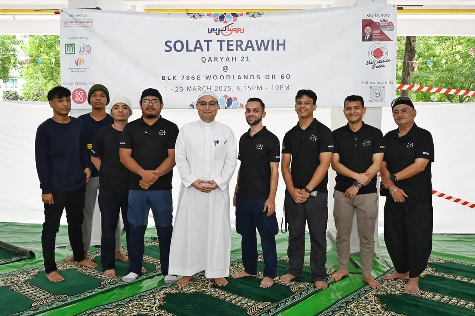 Pengerusi ‘Qaryah 21’, Encik Muhammad Basyar Mohd Yusoff (empat dari kanan), bersama sukarelawan kariah berusia 21 hingga 23 tahun. 