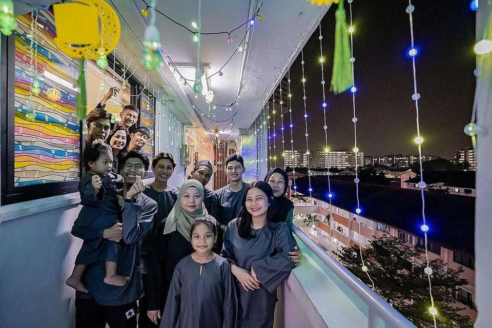 MERIAH: Keluarga 13 orang Encik Farid Difari (paling atas, memegang lampu lap-lip) dan Cik Ai'shah Redwan (bertudung kelabu) telah menyediakan hiasan lampu lap-lip yang lengkap sepanjang koridor mereka hingga menarik perhatian ramai di TikTok. - Foto-foto BH oleh NUR DIYANA TAHA 