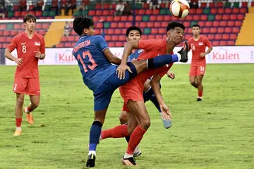 PERMAINAN HAMBAR: Pemain Singapura, Jordan Emaviwe (kanan) bergelut untuk dapatkan bola dengan Phongsakon Trisat menentang Thailand di Sukan SEA Kemboja pada Mei 2023.