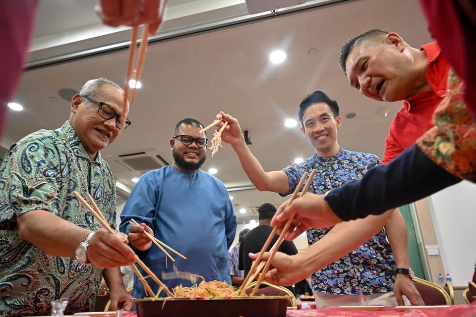 Para hadirin berbeza agama melakukan amalan sambutan Tahun Baru Cina, termasuk melambung Lo Hei. 