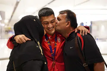 SOKONGAN KELUARGA: Iqbal (tengah) menerima kucupan tahniah daripada ibu bapanya, Yang Che Omar dan Abdul Rahman Abdul Wahid.