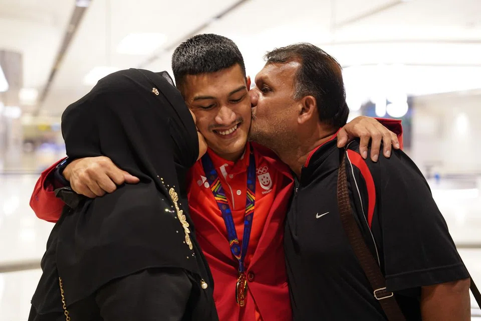 SOKONGAN KELUARGA: Iqbal (tengah) menerima kucupan tahniah daripada ibu bapanya, Yang Che Omar dan Abdul Rahman Abdul Wahid.