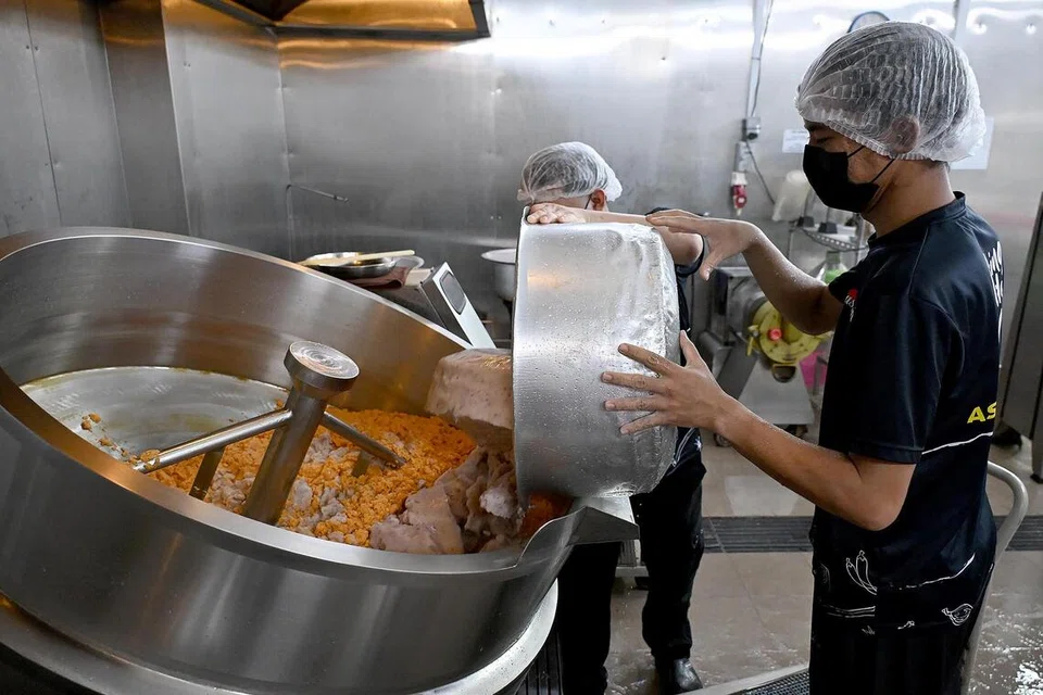 Pekerja di Asyura Paste memasukkan bahan-bahan untuk menghasilkan rempah paling laris dijual, iaitu ayam masak merah.