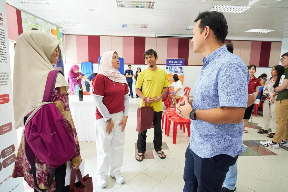 DEKATI PENDUDUK: Menteri Negara Kanan (Tenaga Manusia merangkap Pertahanan) Encik Zaqy Mohamad (kanan) berinteraksi dengan Cik Norsita Abdul (kiri) dan Encik Aziz Wagiman (tiga dari kiri) di Kelab Masyarakat Marsiling pada Ahad. Bersama mereka ialah Eksekutif Kanan Perhubungan dan Pendekatan Korporat NKF, Cik Norazlina Wagiman. 