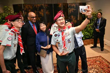 Presiden Tharman Shanmugaratnam dan isterinya, Puan Jane Ittogi, berswafoto bersama penerima Anugerah Pengakap di Istana pada 2 Disember.
