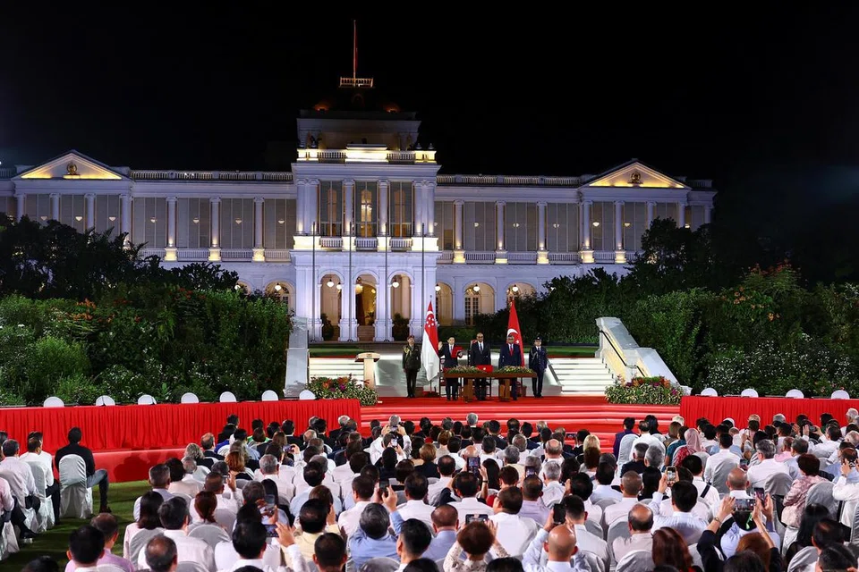 (Dari kiri) Perdana Menteri Singapura yang baru merangkap Menteri Kewangan, Encik Lawrence Wong; Presiden Tharman Shanmugaratnam; dan Ketua Hakim Negara Sundaresh Menon berdiri di atas pentas ketika Encik Wong mengangkat sumpah sebagai Perdana Menteri Singapura keempat di Istana pada 15 Mei. 