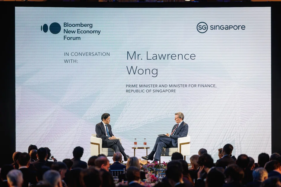 Perdana Menteri Lawrence Wong  (kiri) dalam dialog Forum Ekonomi Baru Bloomberg (NEF), bersama moderator John Micklethwait pada 19 Nov.