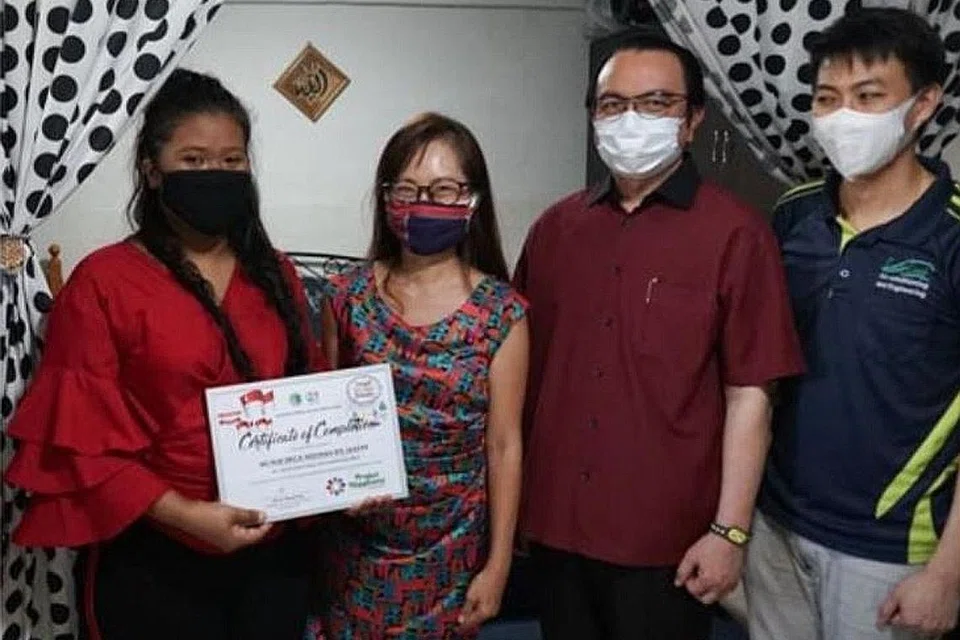 PROJECT HAPPINESS: Cik Nur Erica Medinah Jaffar (paling kiri), merupakan benefisiari yang menerima pengubahsuaian rumahnya daripada penghuni Darul Islah sewaktu Hari Raya tahun lalu.