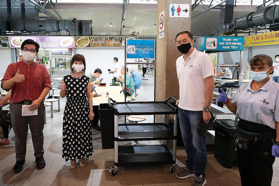 PENGUATKUASAAN DI PUSAT PENJAJA: Dr Amy Khor (dua dari kiri) semasa melawat Pasar dan Pusat Makanan Sims Vista semalam untuk mengingatkan orang ramai bahawa penguatkuasaan bagi peraturan mengembalikan dulang di pusat penjaja akan bermula esok, 1 September dan bagi kedai kopi dan pusat makanan lain bermula 1 Januari depan. - Foto KEMENTERIAN KEMAMPANAN DAN SEKITARAN