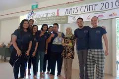 PELAJARI BAHASA DAN SENI MENERUSI PERKHEMAHAN: Anggota Parlimen (AP) GRC Jurong, Cik Rahayu Mahzam (baju bunga) menyampaikan hadiah kepada para peserta Perkhemahan Seni, Akar! yang diadakan awal tahun sambil diiringi Raja Hamzah (dua dari kanan). - Foto VARIASI PERFORMING ARTS