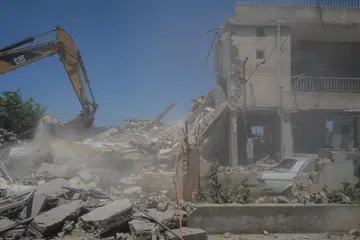 Penyelamat berusaha mencari mangsa di bawah tapak rumah yang hancur selepas serangan udara Israel di Barish, Lebanon.