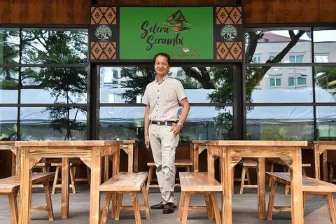 SENTUHAN KEMELAYUAN: Pengerusi Tang Tea House, Encik Johnny Tan, 63 tahun, sedang berdiri di hadapan pintu masuk Selera Serambi yang merupakan jenama baru di bawah Tang Tea House, yang dibuka buat kali pertama di Wisma Geylang Serai. - Foto BH oleh JASMINE CHOONG