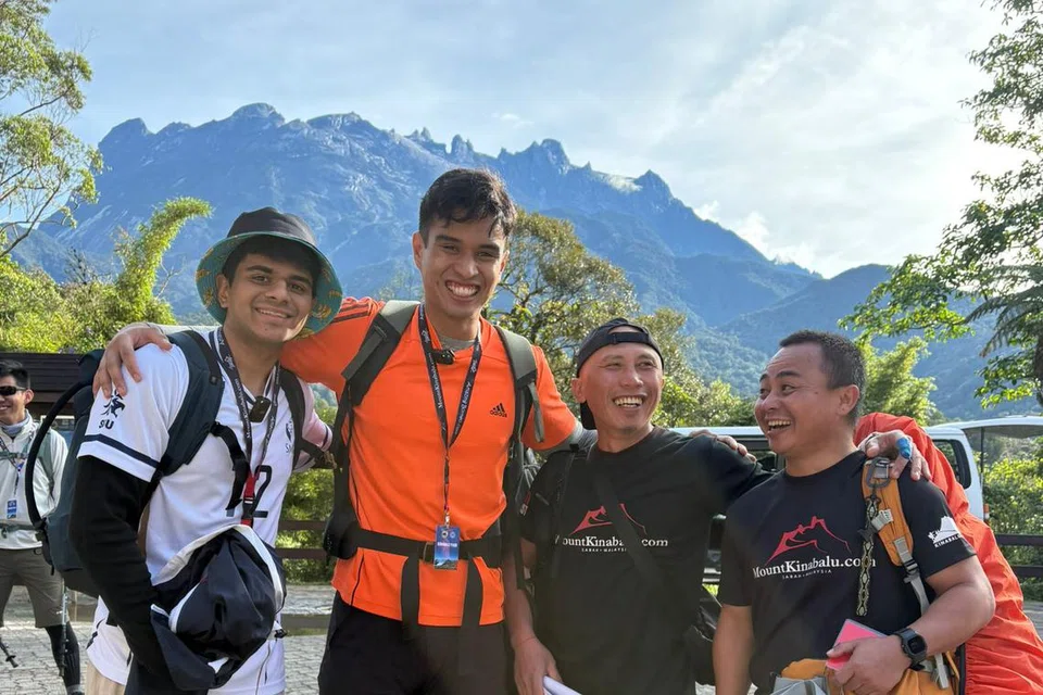 Encik Emyr Uzayr Mohamed Sadri (dua dari kiri) dan Encik Prajesh Dhimant Patel (kiri) di Timpohon Gate pada 20 Mei sebelum memulakan pendakian mereka di Gunung Kinabalu pada 8.30 pagi. Bersama mereka adalah jurupandu pengembara, Encik Billy Sapinggi (paling kanan) dan Encik Cornelius Sanan, yang telah menyelamatkan Encik Prajesh dalam pendakiannya semasa rombongan ekspedisi Sekolah Rendah Tanjong Katong (TKPS) pada 2015.