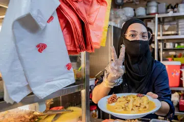 INGIN BANTU GOLONGAN MEMERLUKAN: Cik Hani Isnin di gerainya yang terletak di Pusat Makanan Jalan Kukoh.