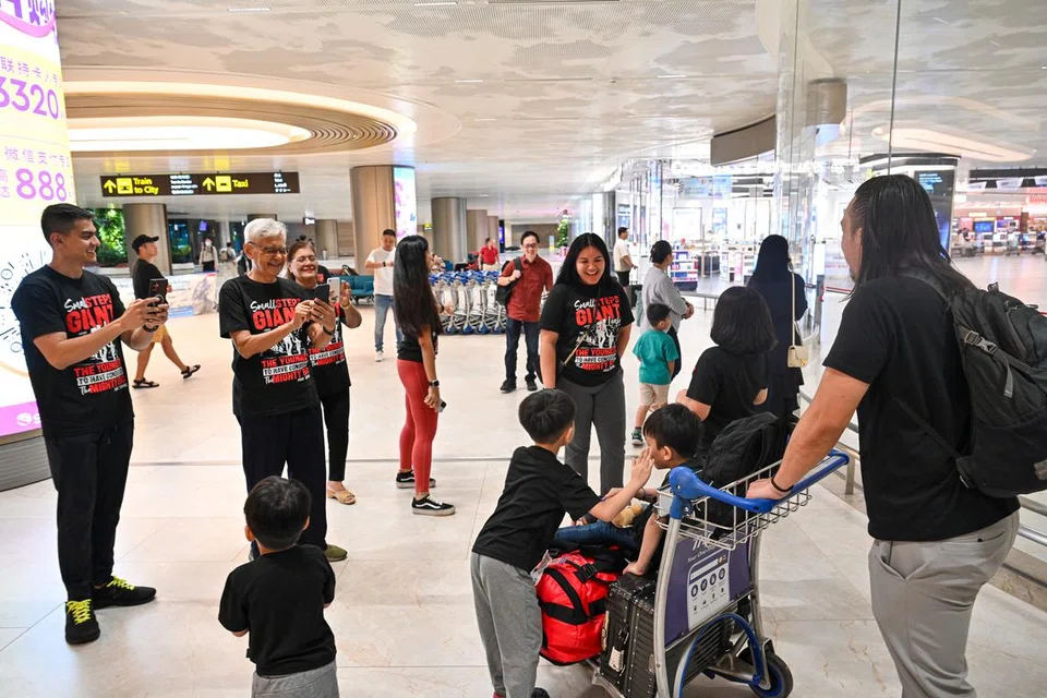Encik Zikri (menolak troli) bersama anak keduanya, Abyan, tiba di Terminal 2 Lapangan Terbang Changi sekitar 6.30 pagi, 6 Mei, dengan sambutan oleh ahli keluarganya berpakaian kemeja hitam sedondon.