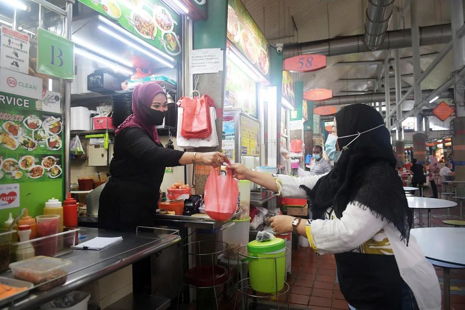 DIGITAL LEBIH MUDAH: Cik Semi Sagi memperkenalkan pilihan pembayaran menerusi PayNow kepada pelanggan di gerainya sejak dua bulan lalu, dan melihat sendiri manfaat pembayaran secara digital yang lebih mudah dan selamat. - Foto BH oleh ALPHONSUS CHERN