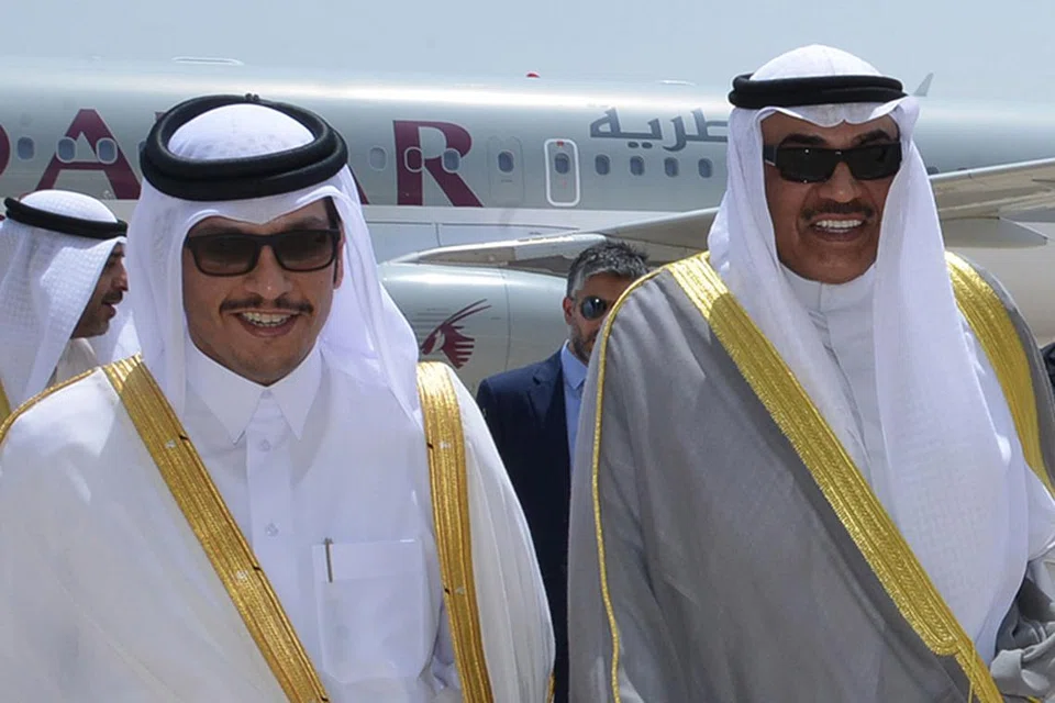 MAHU BERBINCANG: Menteri Luar Qatar, Sheikh Mohammed Abdulrahman Al-Thani (kiri), dan Menteri Luar Kuwait, Sheikh Sabah Khaled Al-Sabah (kanan) berjalan bersama di lapangan terbang di Kuwait, sejurus Sheikh Al-Thani tiba di negara itu. Doha menyatakan bahawa ia bersedia mengadakan perbincangan bagi mengakhiri krisis dengan jiran Teluknya itu. - Foto AFP