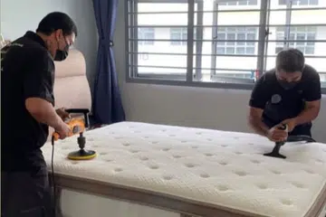 Pengasas Natura Clean Solution, Encik Abdul Muhaimeen Sapiuna (kanan), membersihkan tilam bersama pekerjanya di rumah pelanggan.