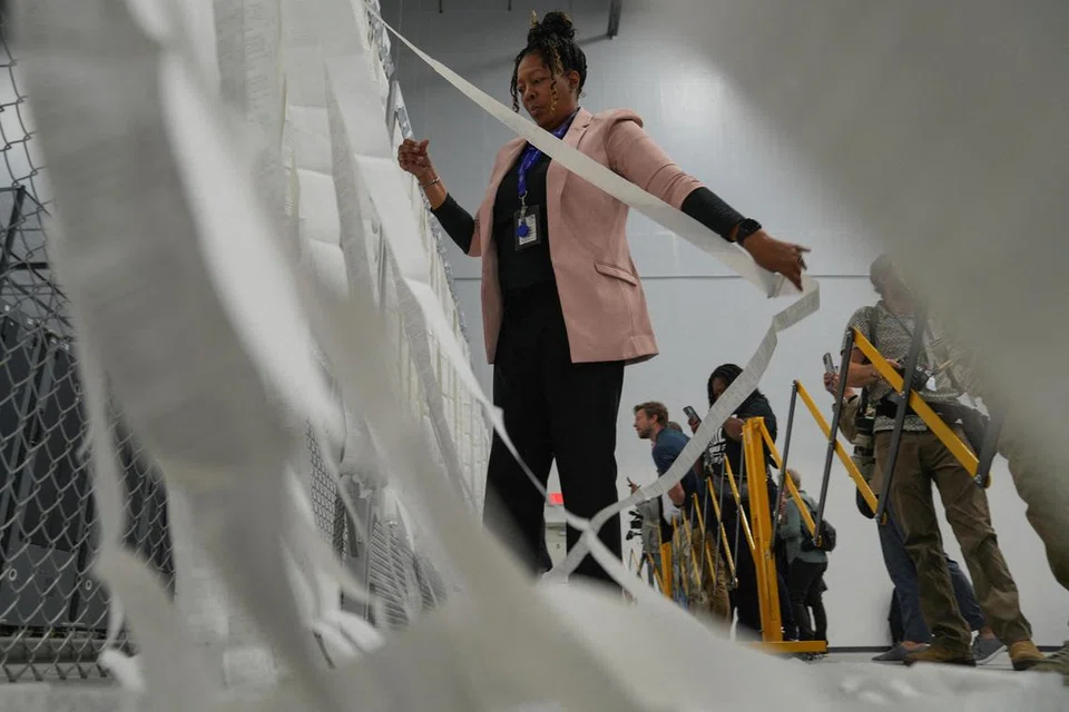 Seorang petugas pilihan raya mendedahkan keputusan awal pengundian sempena Pilihan Raya Presiden Amerika Syarikat 2024 di Pusat Operasi dan Pilihan Raya Daerah Fulton, Fairburn, Georgia, pada Hari Pilihan Raya, 5 November.