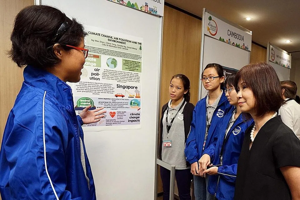 KONGSI ISU ALAM SEKITAR: Para pelajar Sekolah CHIJ St. Nicholas Girls mengongsi projek mereka dengan Dr Amy Khor (kanan) di majlis pelancaran Program Alam Sekitar Sunburst STEP-NUS 2016. - Foto STEP