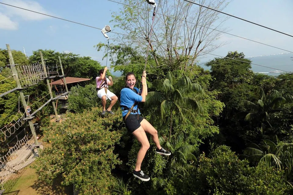 GAGAHI CABARAN PETUALANG DI MEGA ADVENTURE: Bagi yang berani, mereka boleh melakukan aktiviti MegaZip, kegiatan aktiviti meluncur sepanjang 450 meter melalui hutan dan pantai di bawah. Anda juga boleh cuba gagahi 'obstacle course treetop' tiga tingkat dengan loncatan 15 meter. Jika ingin bermain lompat-lompat, keluarga juga boleh ke MegaBounce dan lonjak di trampolin setinggi lapan meter di Pantai Siloso. Lungsuri laman web Mega Adventure bagi promosi yang ditawarkan. - Foto PANDORA WONG