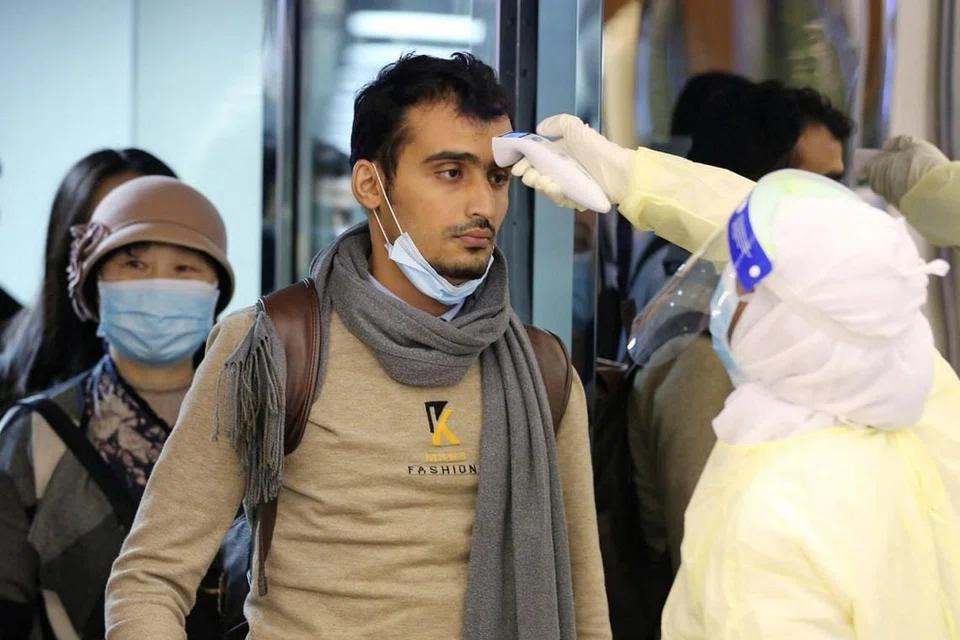 AMBIL LANGKAH BERJAGA-JAGA: Penumpang, yang tiba dari China memakai pelitup untuk menghalang penularan virus wuhan, diperiksa setibanya mereka di Lapangan Terbang Antarabangsa King Khalid di Riyadh, Arab Saudi, kelmarin. - Foto REUTERS