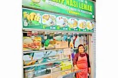 LEBIH RAMAI PELANGGAN BUKAN MELAYU: Cik Zubaidah Sallehudin, pembantu gerai Aliff Nasi Lemak di Pusat Penjaja Serangoon Garden mendapati perniagaan masih bagus kerana tidak banyak gerai Melayu, lantas kurang persaingan.