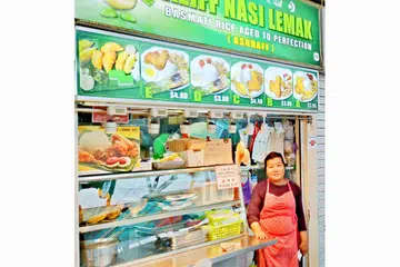 LEBIH RAMAI PELANGGAN BUKAN MELAYU: Cik Zubaidah Sallehudin, pembantu gerai Aliff Nasi Lemak di Pusat Penjaja Serangoon Garden mendapati perniagaan masih bagus kerana tidak banyak gerai Melayu, lantas kurang persaingan.