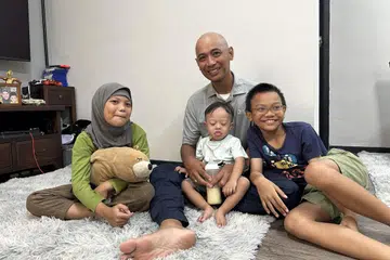 KEKAL CEKAL: Bapa tunggal Encik Kamal Othman, 49 tahun, tabah menghadapi cabaran membesarkan ketiga-tiga anaknya, (dari kiri) Khayla Damia, sembilan tahun; Khayr Dasuki, dua tahun, yang menghidap Sindrom Down; dan Khalish Daiman, 11 tahun.