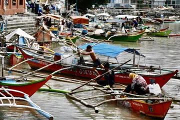 Seorang nelayan Filipina berusaha menambat sampannya sebagai menjangkakan kesan ribut tropika Bebinca melanda  bandar Bacoor, Manila. 