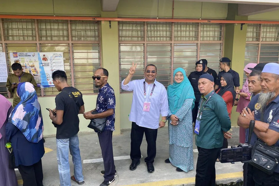TURUT MENGUNDI: Menteri Besar sementara Kedah, Datuk Seri Muhammad Sanusi Md Nor (mengangkat tangan), melakukan tanggungjawab untuk mengundi dalam pilihan raya negeri ke-15 (PRN15).