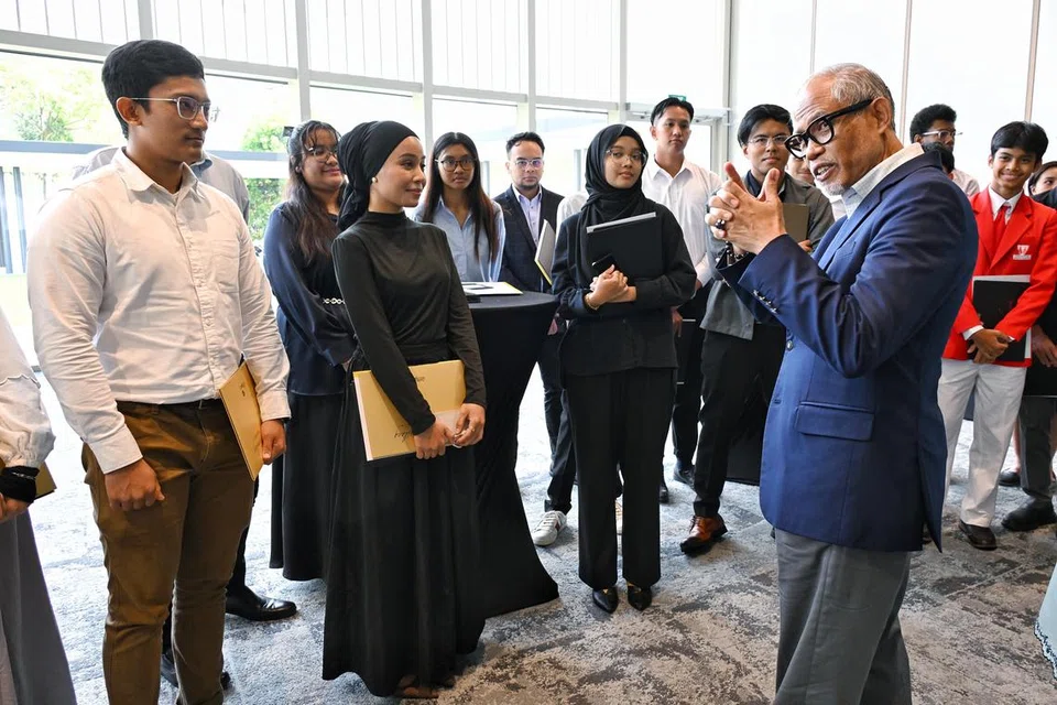Encik Taufiq Abdul Rahman (kiri) dan Cik Sri Mardiah Suharman (dua dari kiri) beramah mesra bersama Menteri Bertanggungjawab bagi Ehwal Masyarakat Islam, Encik Masagos Zulkifli Masagos Mohamad (depan, kanan), di majlis penyampaian Anugerah Mendaki 2024 pada 20 Oktober. 