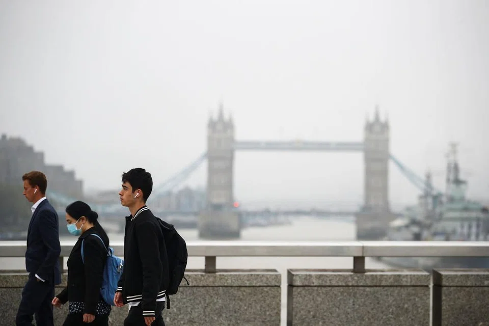 Beberapa orang dilihat sedang berjalan di London Bridge pada 21 September 2020. - FOTO: REUTERS