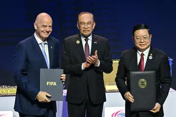 Presiden Persekutuan Persatuan Bola Sepak Antarabangsa (Fifa), Gianni Infantino (kiri); Perdana Menteri Malaysia yang juga Pengerusi Asean 2025, Datuk Seri Anwar Ibrahim (tengah); serta Setiausaha Agung Asean, Encik Kao Kim Hourn; di majlis menandatangani Memorandum Persefahaman (MOU) Asean-Fifa di luar Sidang Kemuncak Asean ke-47 di Kuala Lumpur, pada 26 Oktober.
