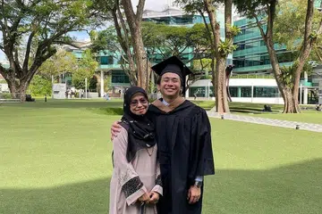 BEKERJA DARI RUMAH: Encik Muhd Wafir, 26 tahun, telah bekerja sebagai pakar perkhidmatan pelanggan di Hubspot sejak Jun tahun lalu. Gambar menunjukkan beliau bersama ibunya, Cik Arniati Asmani, semasa majlis konvokesyen beliau minggu lalu. - Foto ihsan ARNIATI ASMANI