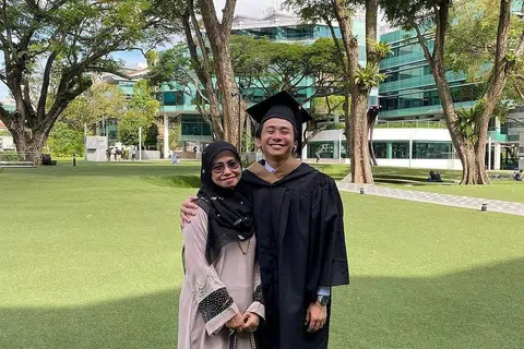 BEKERJA DARI RUMAH: Encik Muhd Wafir, 26 tahun, telah bekerja sebagai pakar perkhidmatan pelanggan di Hubspot sejak Jun tahun lalu. Gambar menunjukkan beliau bersama ibunya, Cik Arniati Asmani, semasa majlis konvokesyen beliau minggu lalu. - Foto ihsan ARNIATI ASMANI