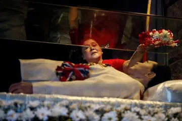 Bekas wanita pertama Imelda Marcos meletak bunga, pada 2 Julai 2014, di keranda kaca suaminya, bekas presiden Ferdinand Marcos, yang masih tidak dikuburkan selepas kematiannya pada 1989, 