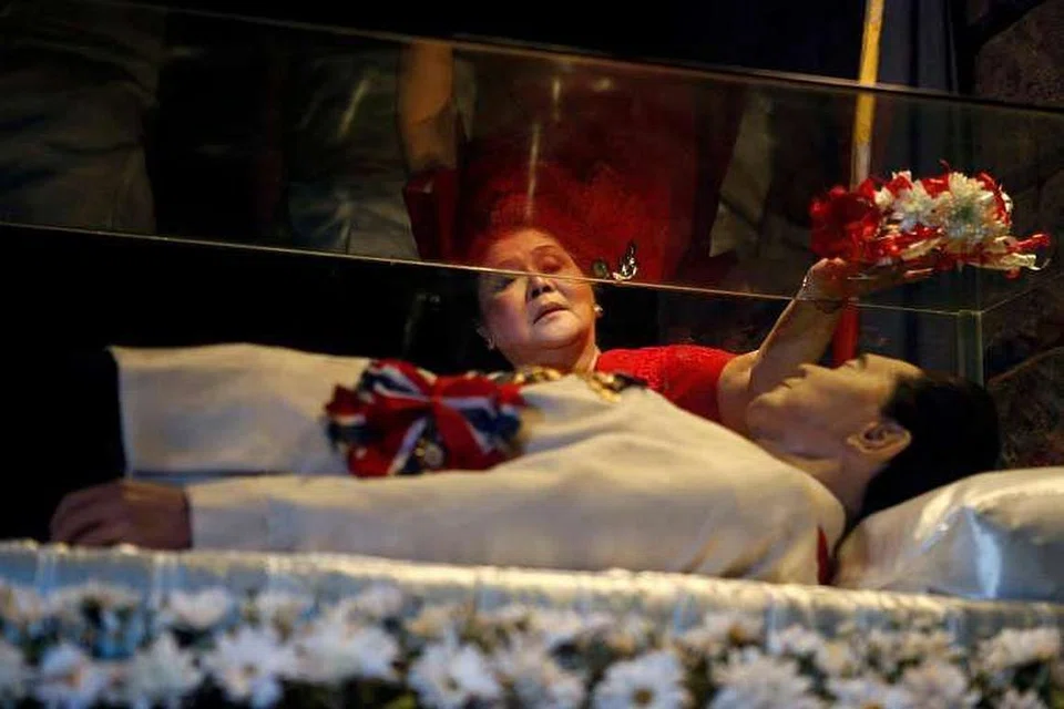 Bekas wanita pertama Imelda Marcos meletak bunga, pada 2 Julai 2014, di keranda kaca suaminya, bekas presiden Ferdinand Marcos, yang masih tidak dikuburkan selepas kematiannya pada 1989, 