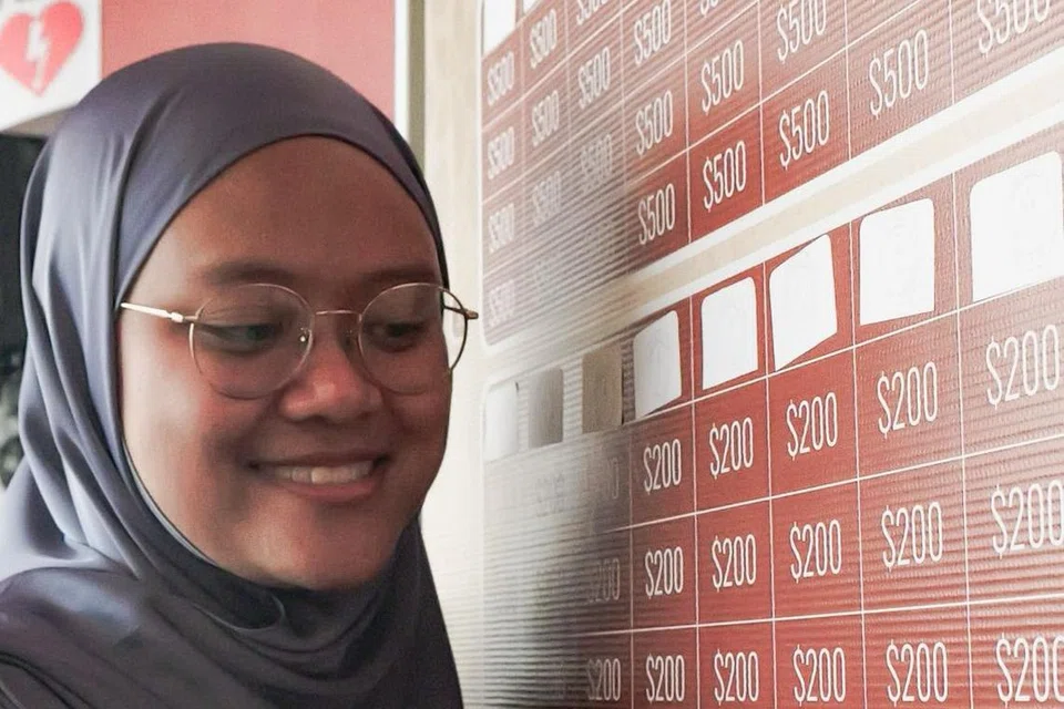 Ustazah Nursakina Khalida Osman, menunjukkan papan infak di ekspo ‘Halal International 2024’.