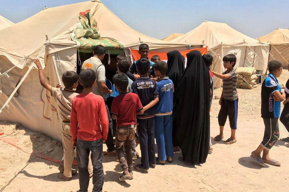 DAPAT BANTUAN: Para penduduk yang sempat melarikan diri dari bandar Fallujah, yang dikuasai ISIS dan kini diserang tentera Iraq, diberi bantuan bahan makanan dan keperluan lain oleh pemerintah Iraq di sebuah khemah sementara. - Foto AFP