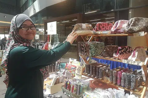 LEBIH MAHIR BERNIAGA: Cik Nurerfani Mohd Khair belajar cara mendekati pelanggan dan meletakkan harga berpatutan pada beg jahitan tangannya daripada perusahaan sosial Enterprising Mums United (EMU). - Foto BH oleh NUR DHUHA ESOOF