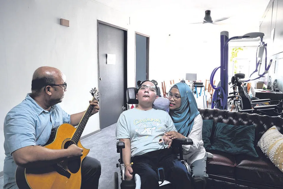 SOKONGAN KUKUH KELUARGA: Encik Razib, bersama Cik Anisah, sering bermain gitar untuk Cik Nuruljannah yang meminati muzik sebagai antara usaha menyokong pemulihan anaknya itu. - Foto MOHAMMAD RAZIB SAMSUDIN