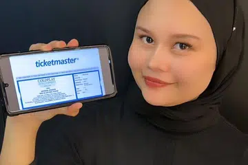 GEMBIRA: Selepas kecewa gagal mendapat tiket konsert Coldplay di Kuala Lumpur, Cik Aida Daud yang berasal dari Pulau Pinang, gembira apabila akhirnya berjaya mendapat tiket menyaksikan kumpulan rok popular dari Britain itu di Singapura.